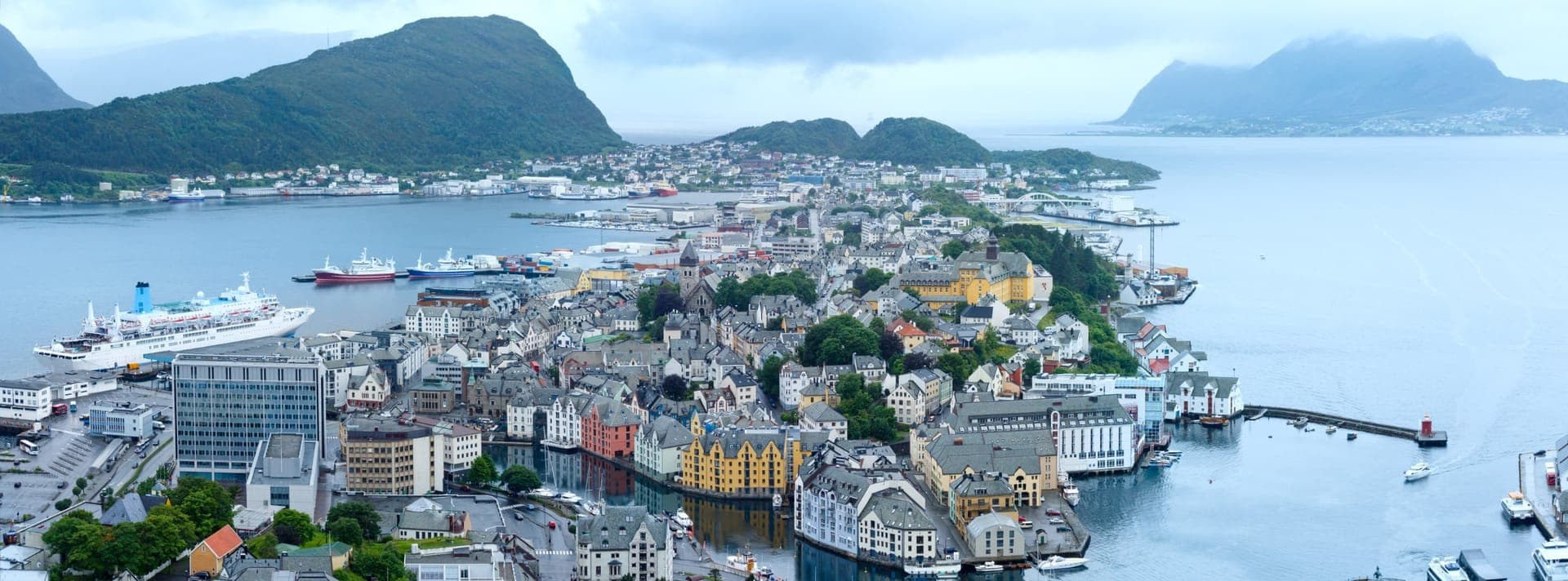 Panoramablick über die Hafenstadt Ålesund mit Kreuzfahrtschiff, aufgenommen vom Aussichtspunkt Aksla