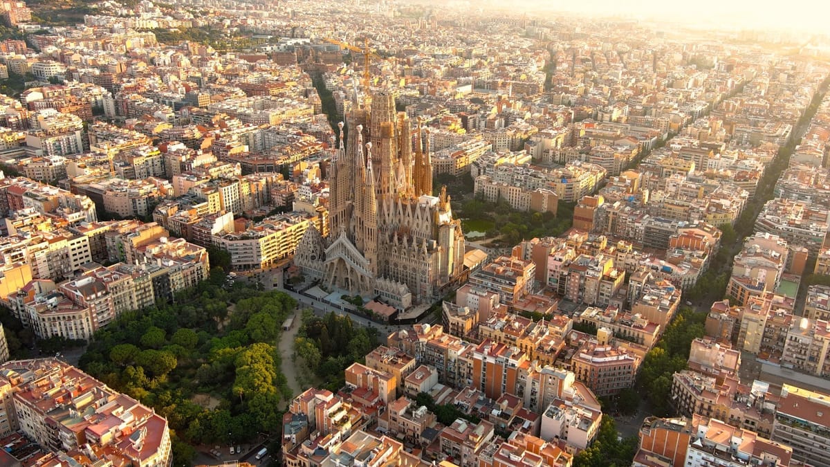 Die Sagrada Família aus der Luft im Morgenlicht, umgeben vom dichten Häuserraster des Eixample