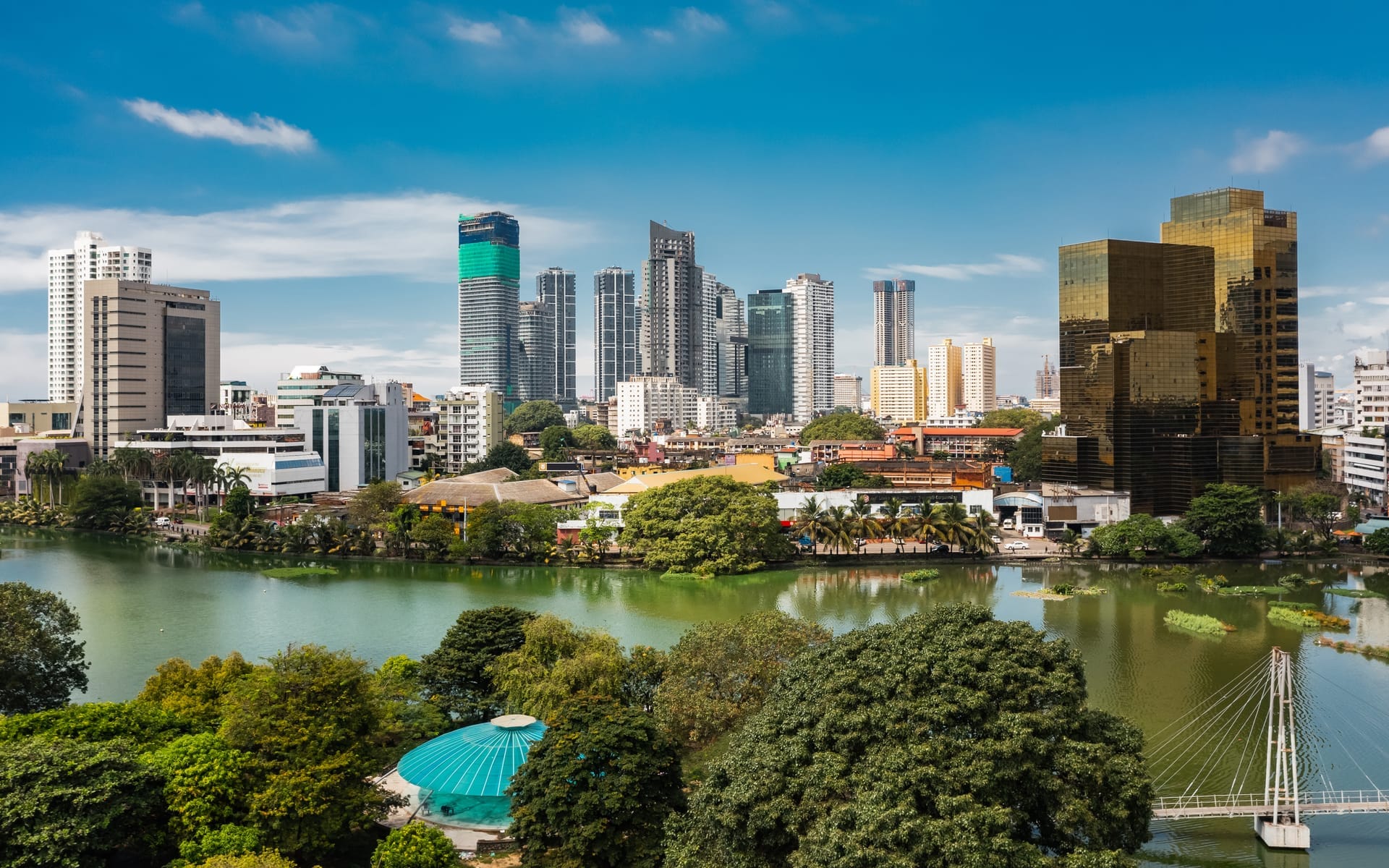 Luftbild der Skyline von Colombo mit Hochhäusern hinter dem grünen Ufer des Beira-Sees