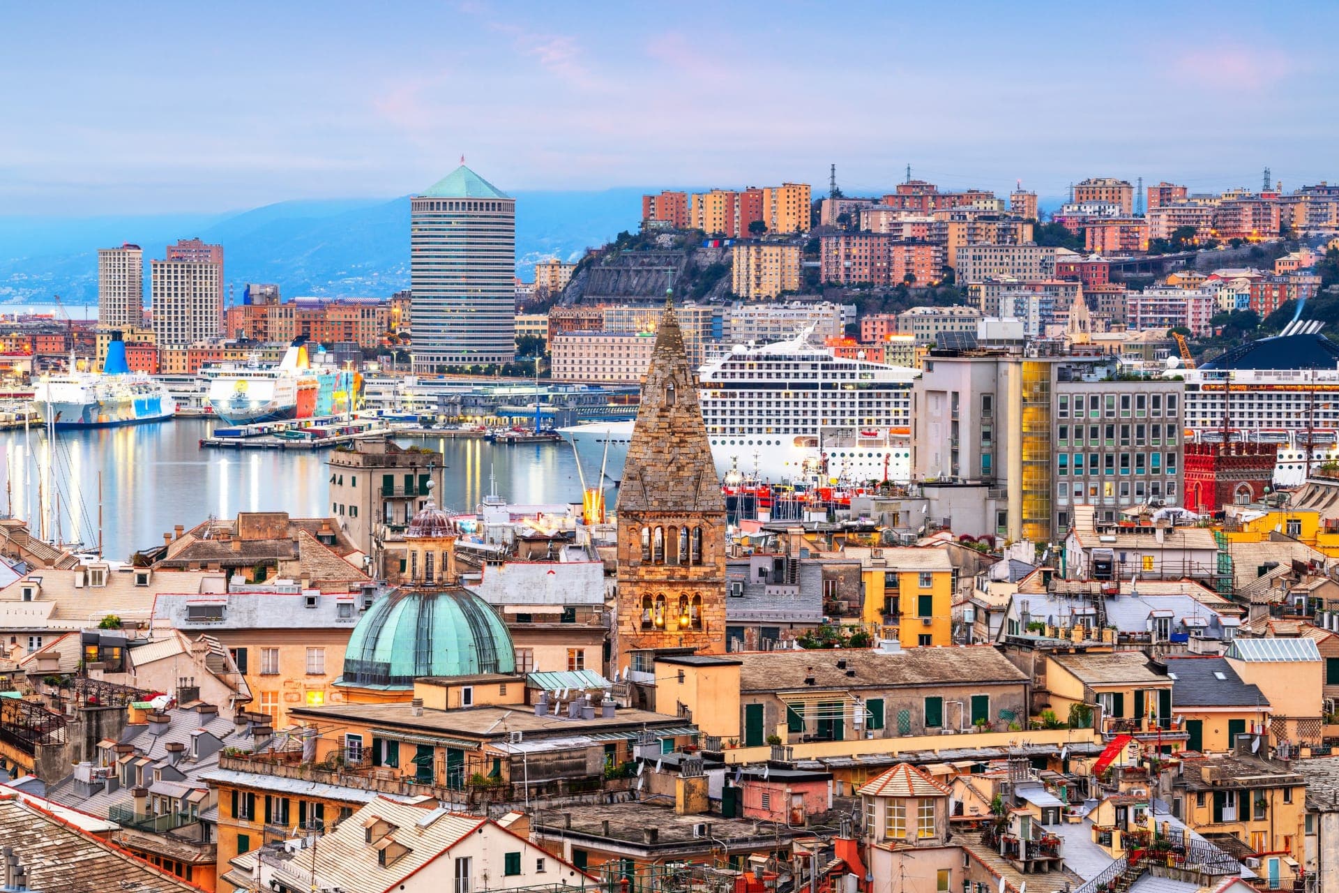Der Alte Hafen von Genua mit Kreuzfahrtschiff und Skyline in der Abenddämmerung