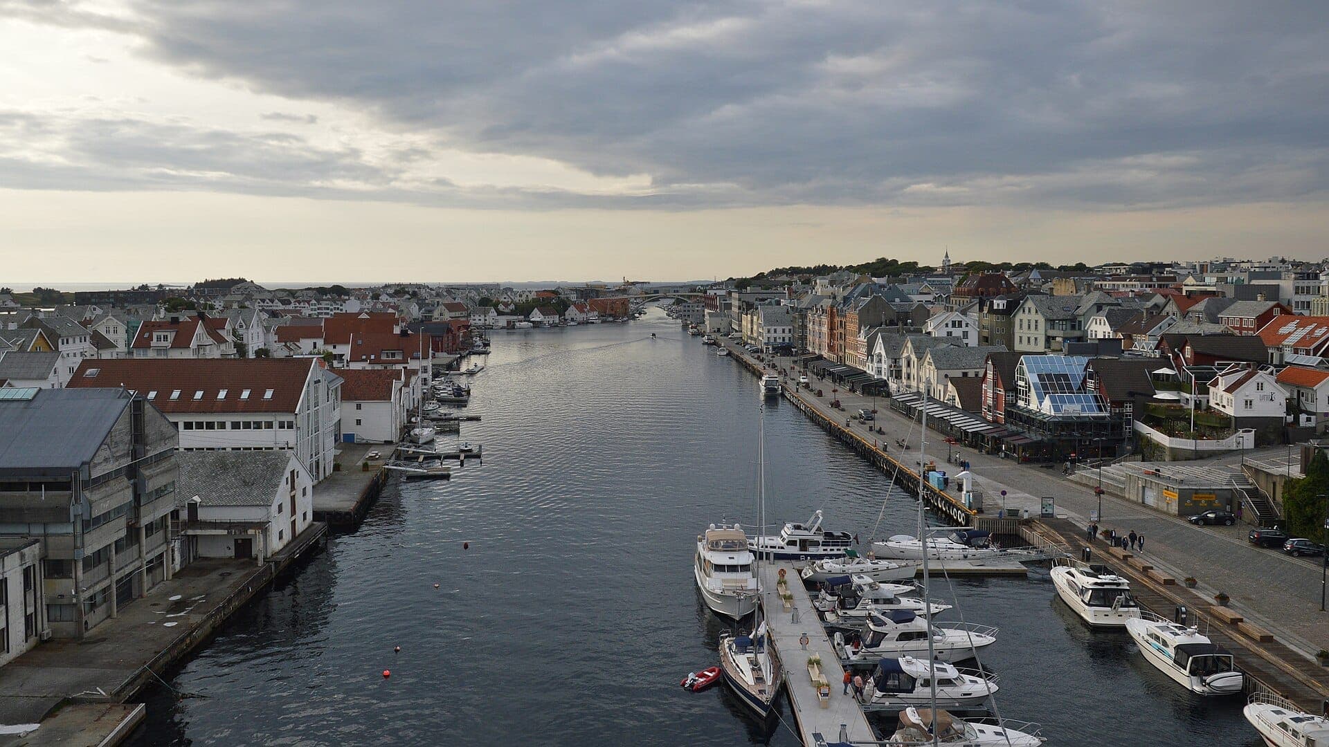 Blick über den Kanal Smedasundet in Haugesund mit Marina, Speicherhäusern und bunter Häuserzeile an der Uferpromenade