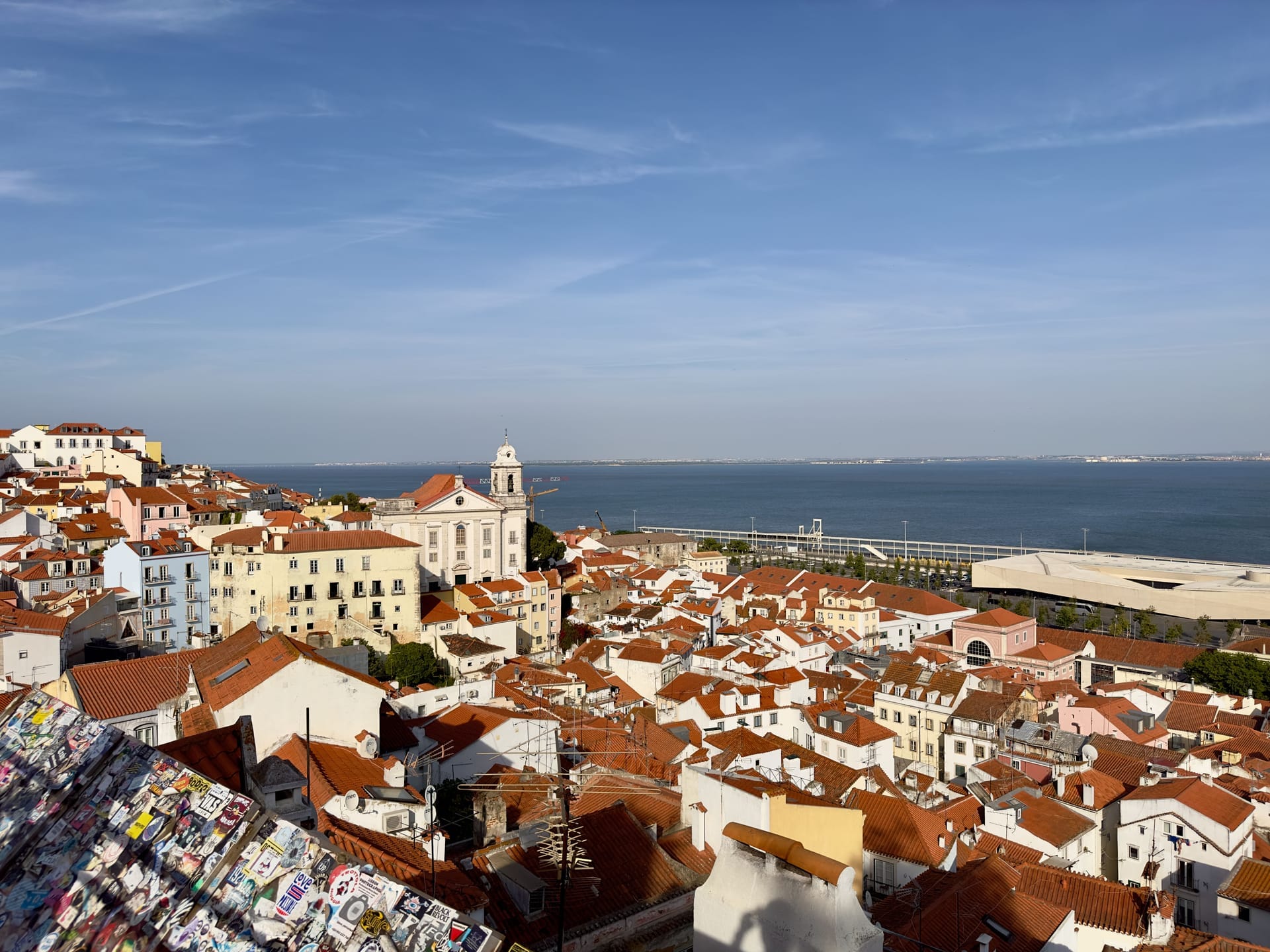 Blick über die roten Ziegeldächer der Alfama auf den Tejo, links der weiße Turm der Kirche Santo Estêvão