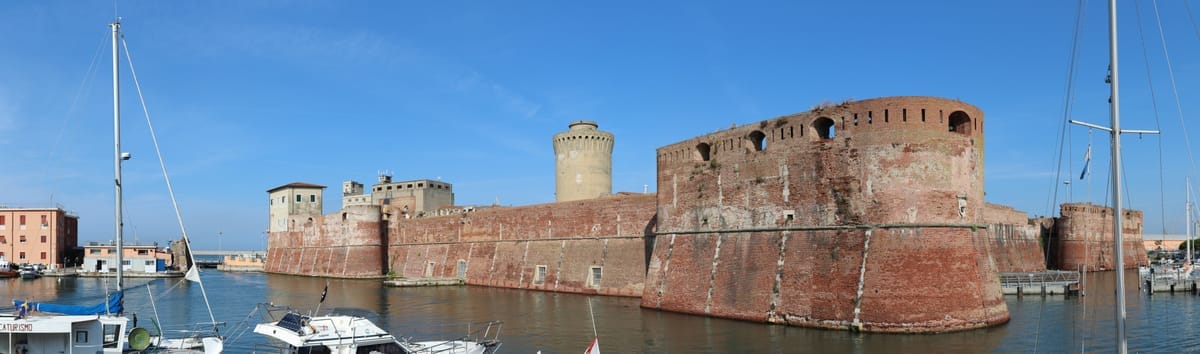 Panorama der Fortezza Vecchia in Livorno mit ihren Backsteinmauern am Wasser und Sportbooten im Vordergrund