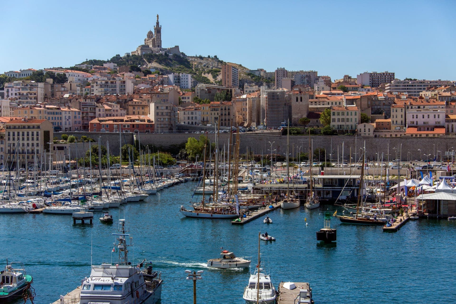 Der Alte Hafen von Marseille mit Booten und Notre-Dame de la Garde im Hintergrund