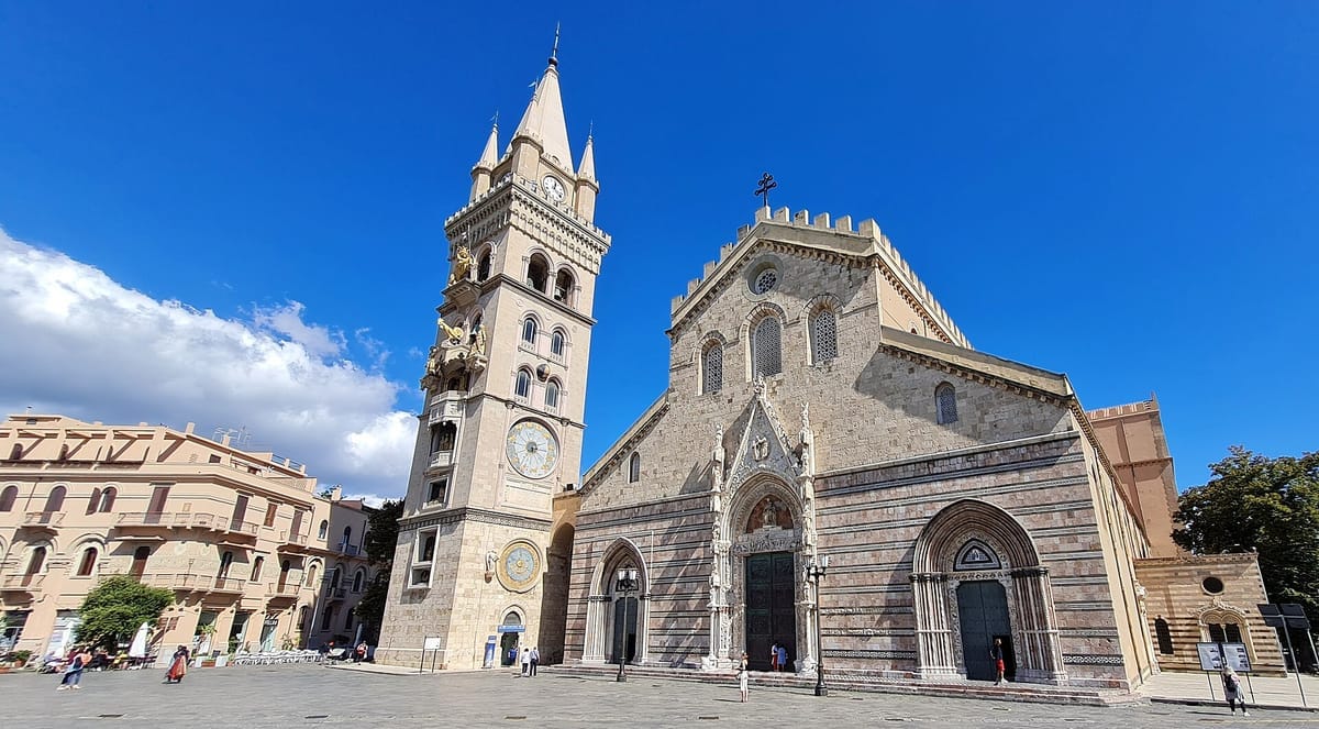 Der Dom von Messina mit gestreifter Marmorfassade und dem freistehenden Campanile, in dessen Turm die runden Zifferblätter der astronomischen Uhr sitzen