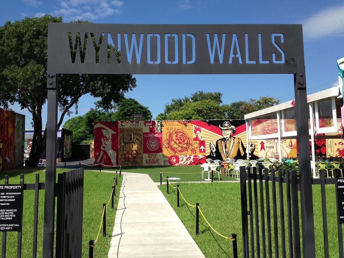 Eingangstor der Wynwood Walls in Miami, dahinter großflächige Murals an den Hallenwänden