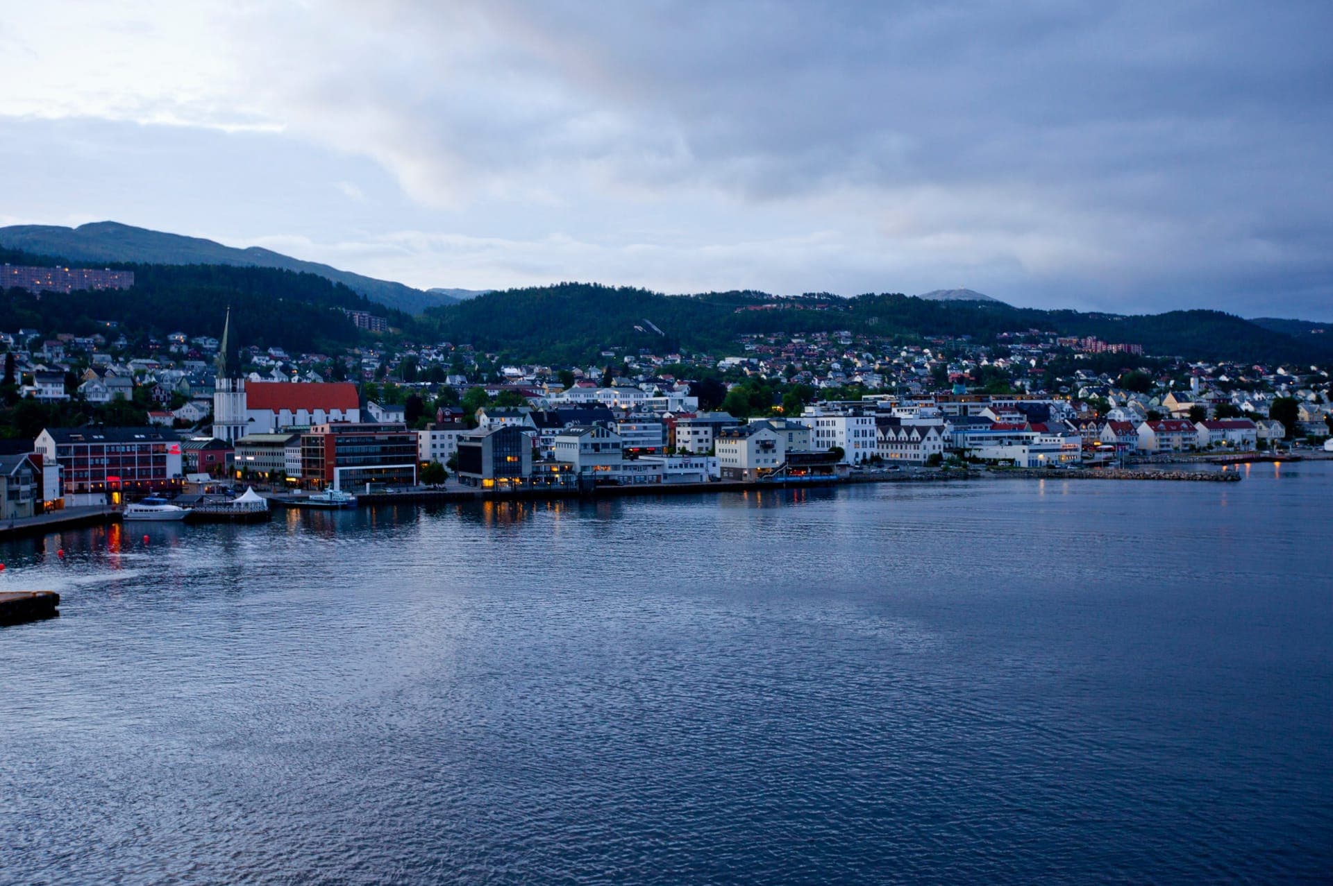 Blick über Molde mit Hafen und den schneebedeckten Gipfeln der Romsdalsalpen im Hintergrund