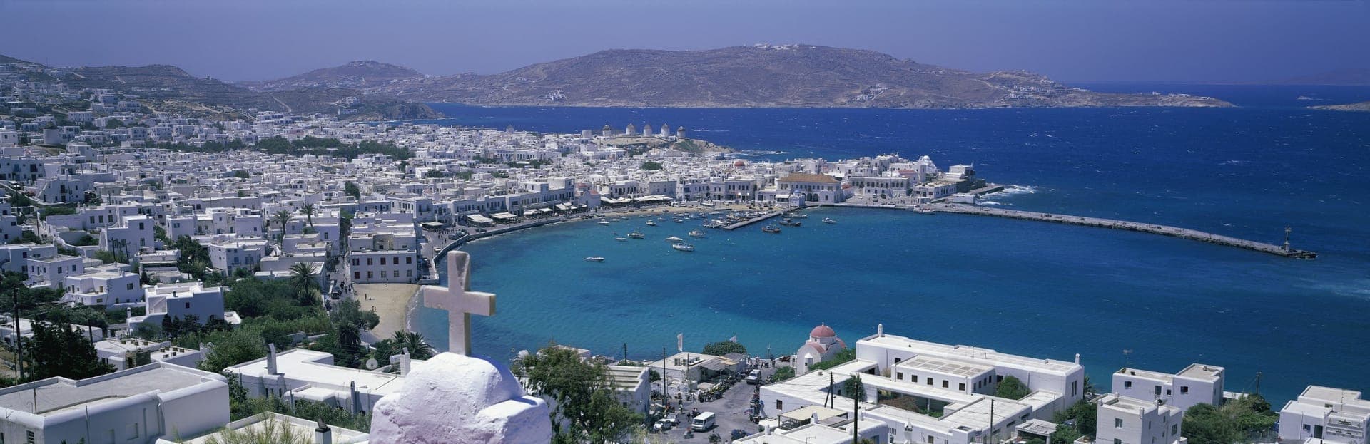Blick von oben über die weißen Häuser der Chora auf die Bucht des alten Hafens von Mykonos