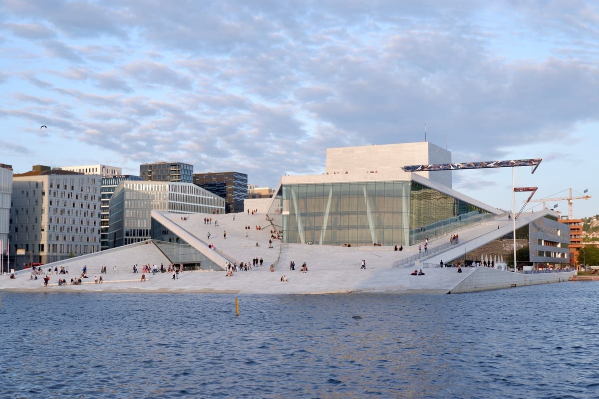 Opernhaus Oslo mit begehbarem Marmordach und Spaziergängern am Wasser von Bjørvika
