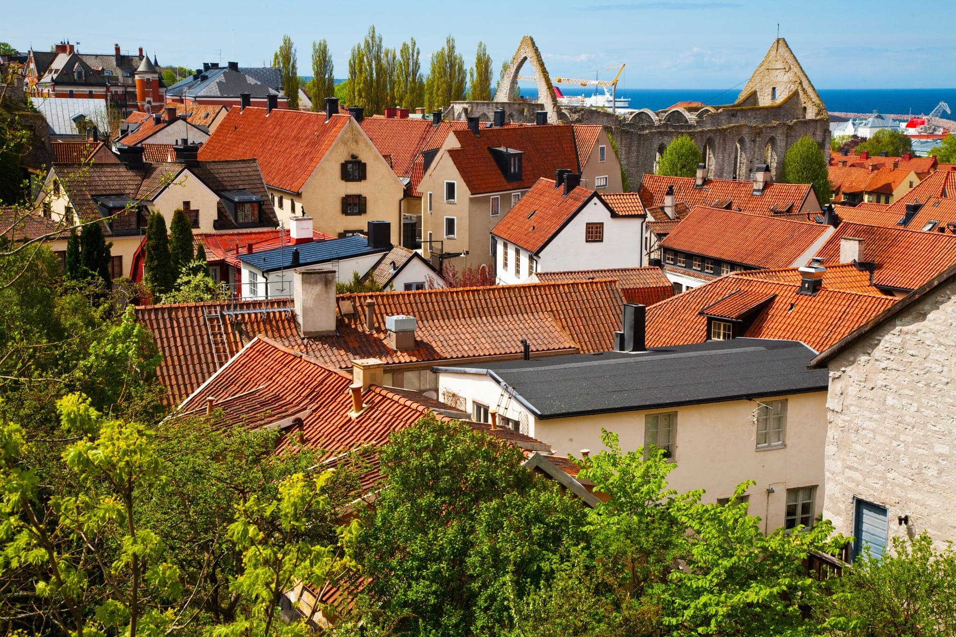 Blick über die Dächer der Altstadt von Visby mit Ringmauer, Kirchtürmen und der Ostsee im Hintergrund