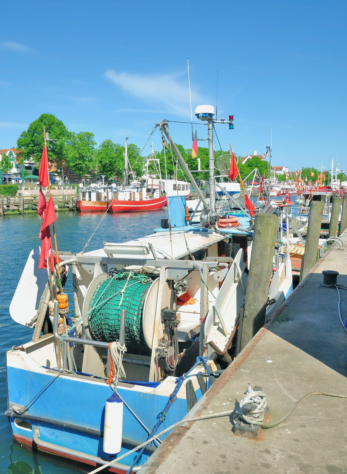 Fischkutter und Ausflugsboote am Alten Strom mit den Häusern der Uferpromenade