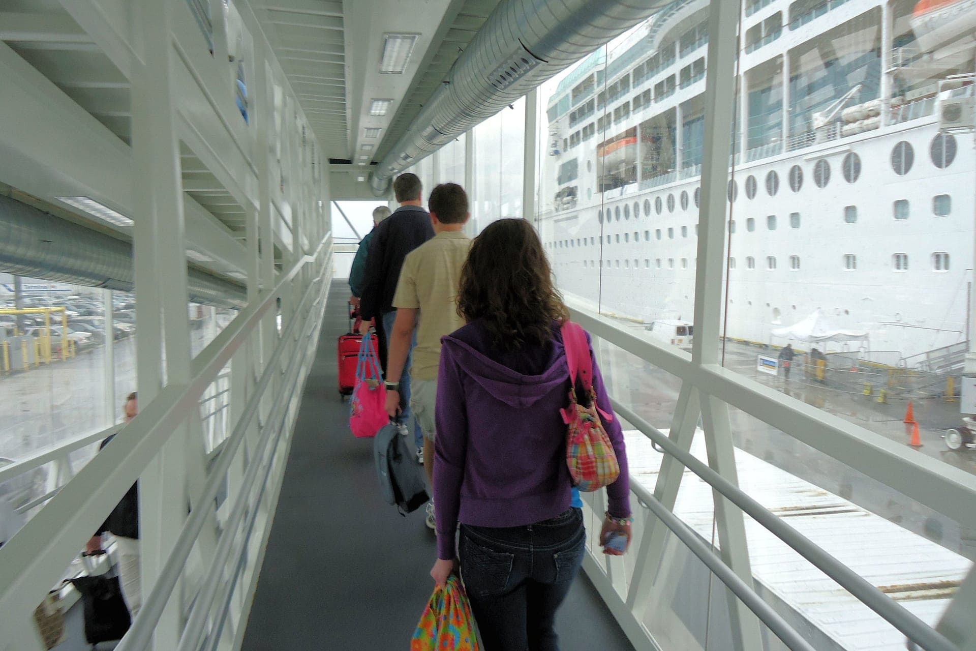 Reisende checken am Kreuzfahrtterminal ein und zeigen ihre Bordkarte vor
