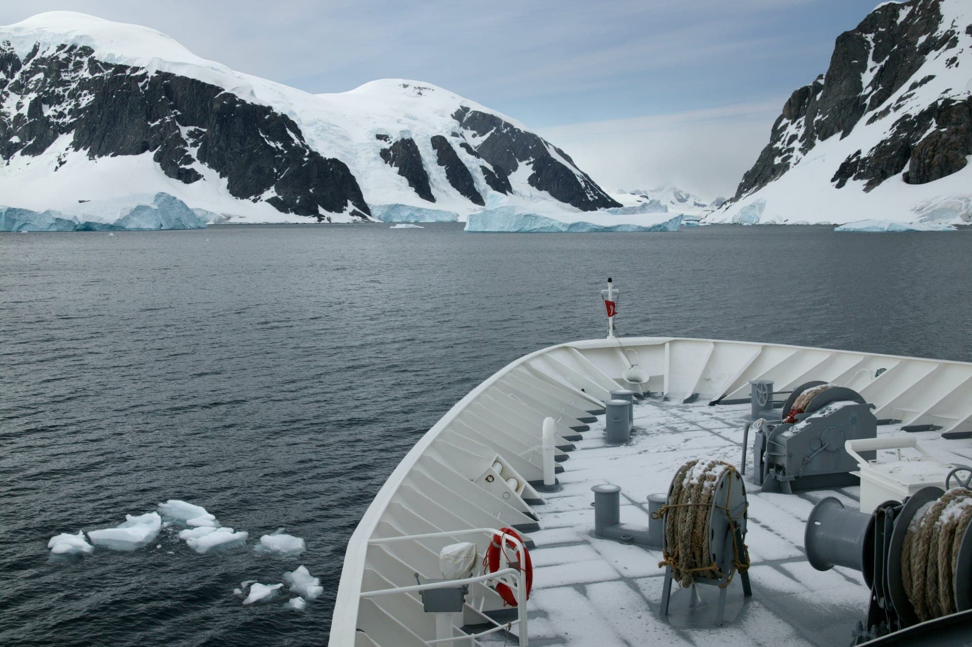 Kleines Expeditionsschiff vor Eisbergen in der Antarktis
