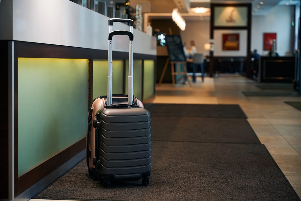 Zwei Koffer stehen an der Rezeption einer modernen Hotellobby