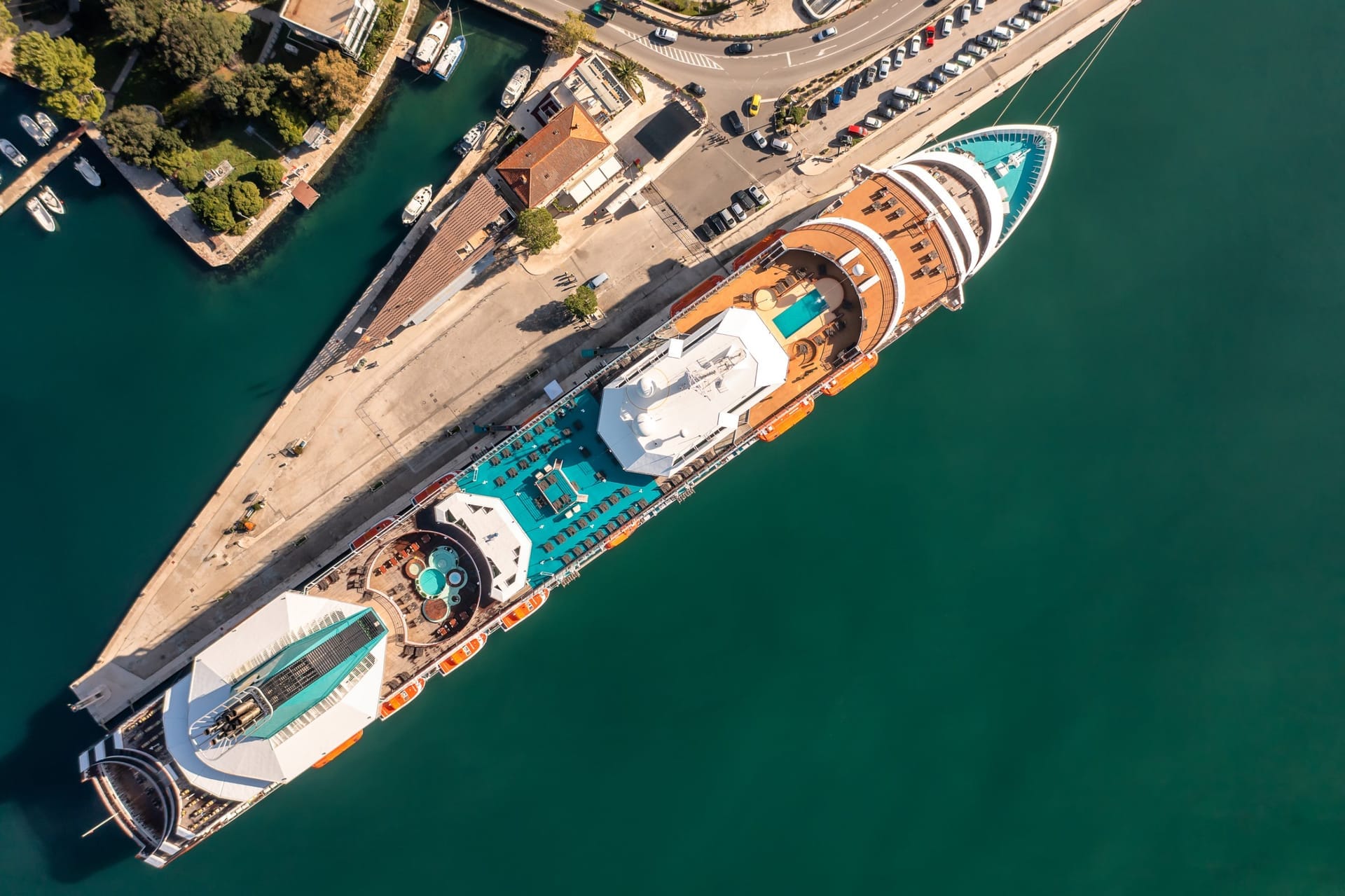 Riesiges modernes Kreuzfahrtschiff am Kai neben deutlich kleineren Gebäuden