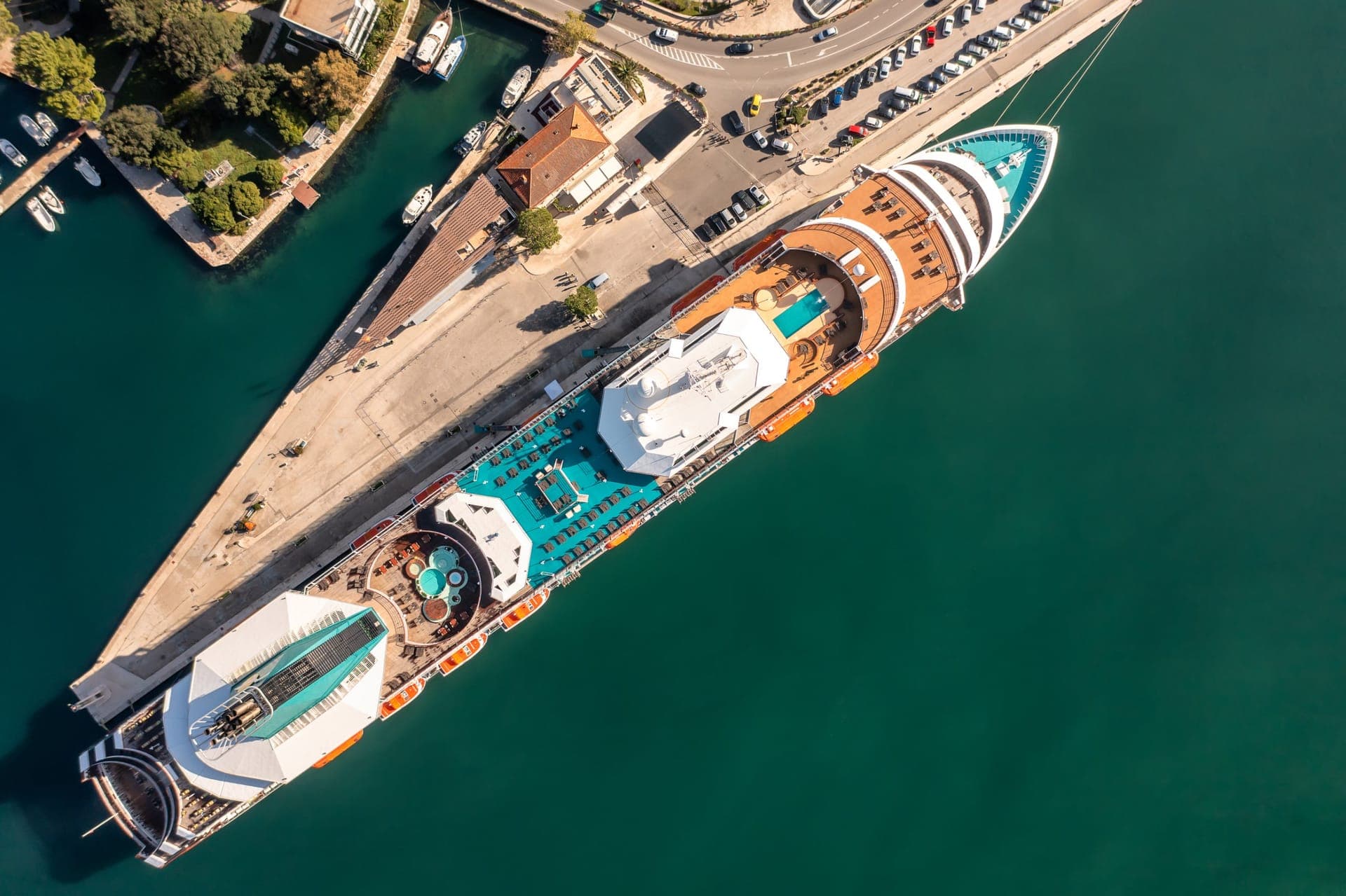 Riesiges modernes Kreuzfahrtschiff am Kai neben deutlich kleineren Gebäuden