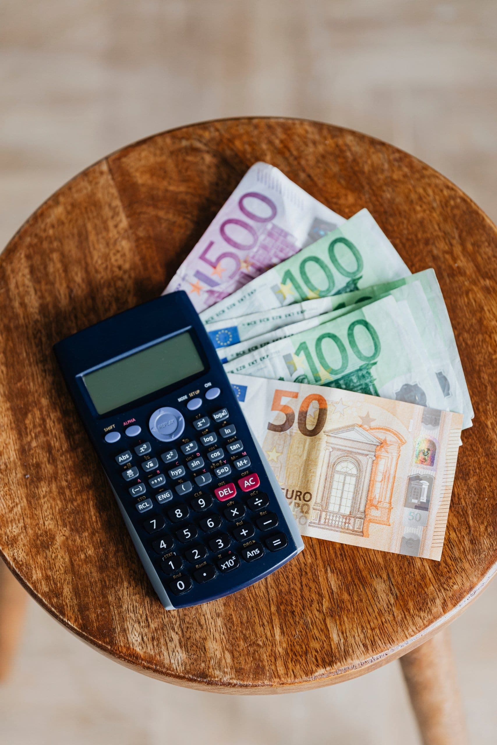 Taschenrechner und Euro-Geldscheine bei der Budgetplanung für eine Kreuzfahrt