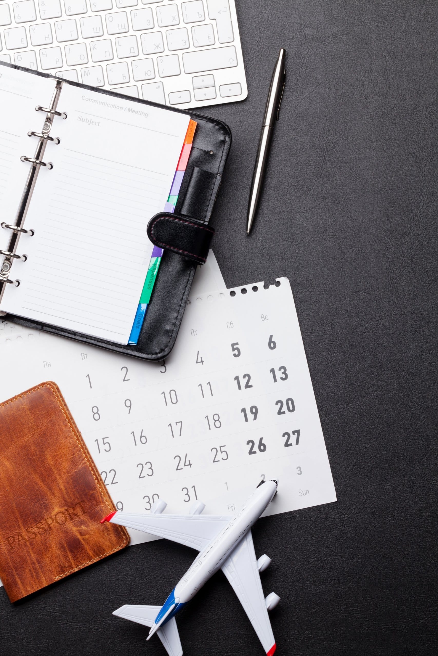 Kalender und Buchungsunterlagen einer Kreuzfahrt mit Stift zur Terminplanung