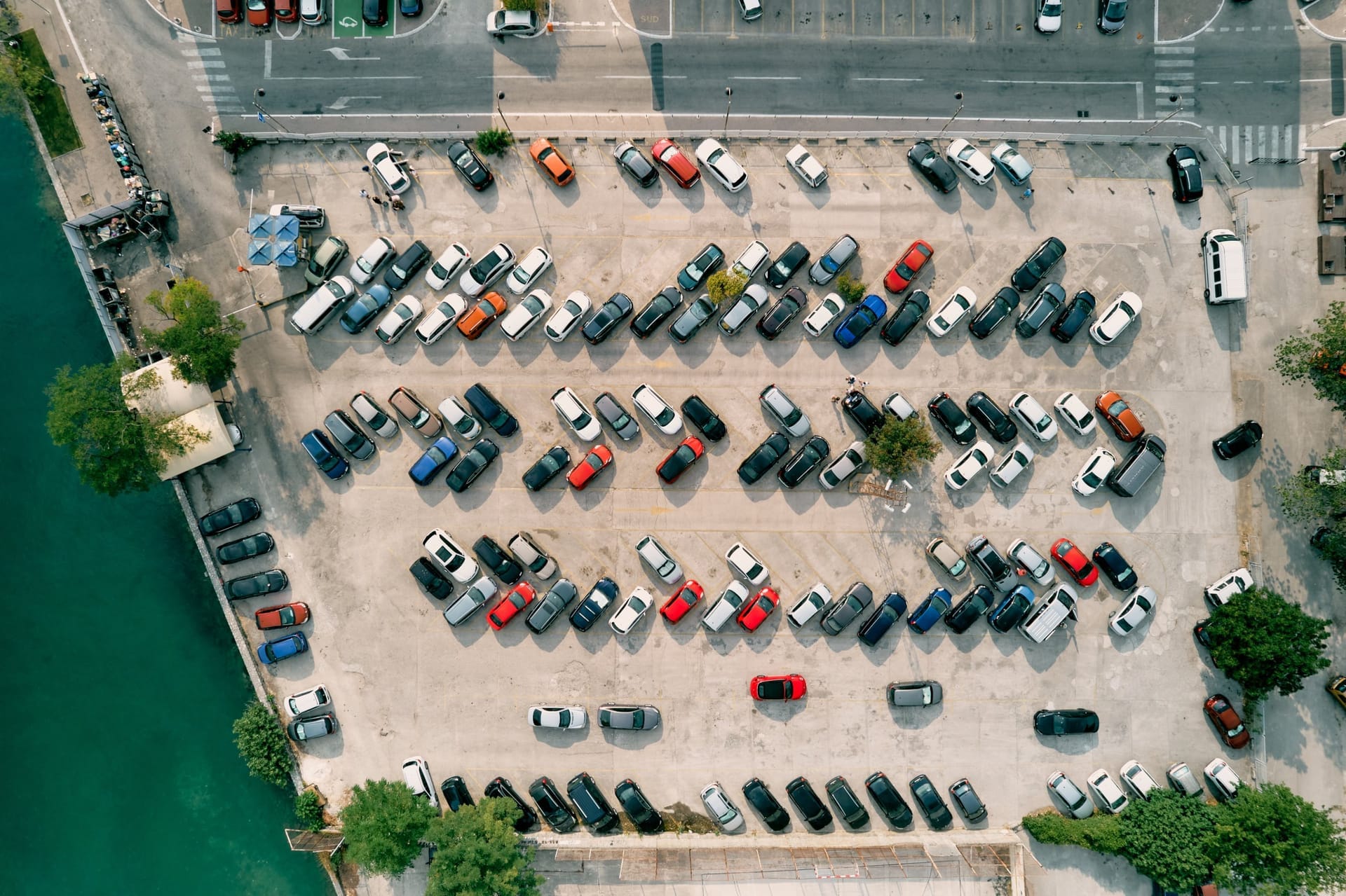 Luftaufnahme eines dicht belegten Parkplatzes direkt am Hafenkai