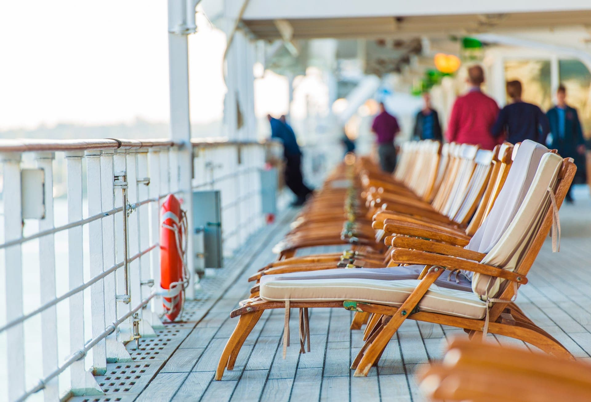 Reihe von Liegestühlen auf dem offenen Promenadendeck eines Kreuzfahrtschiffs