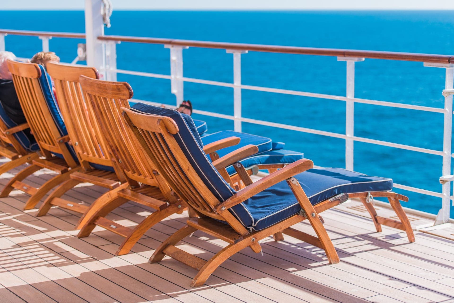Liegestuhl am Pool eines Kreuzfahrtschiffs mit Blick auf das offene Meer