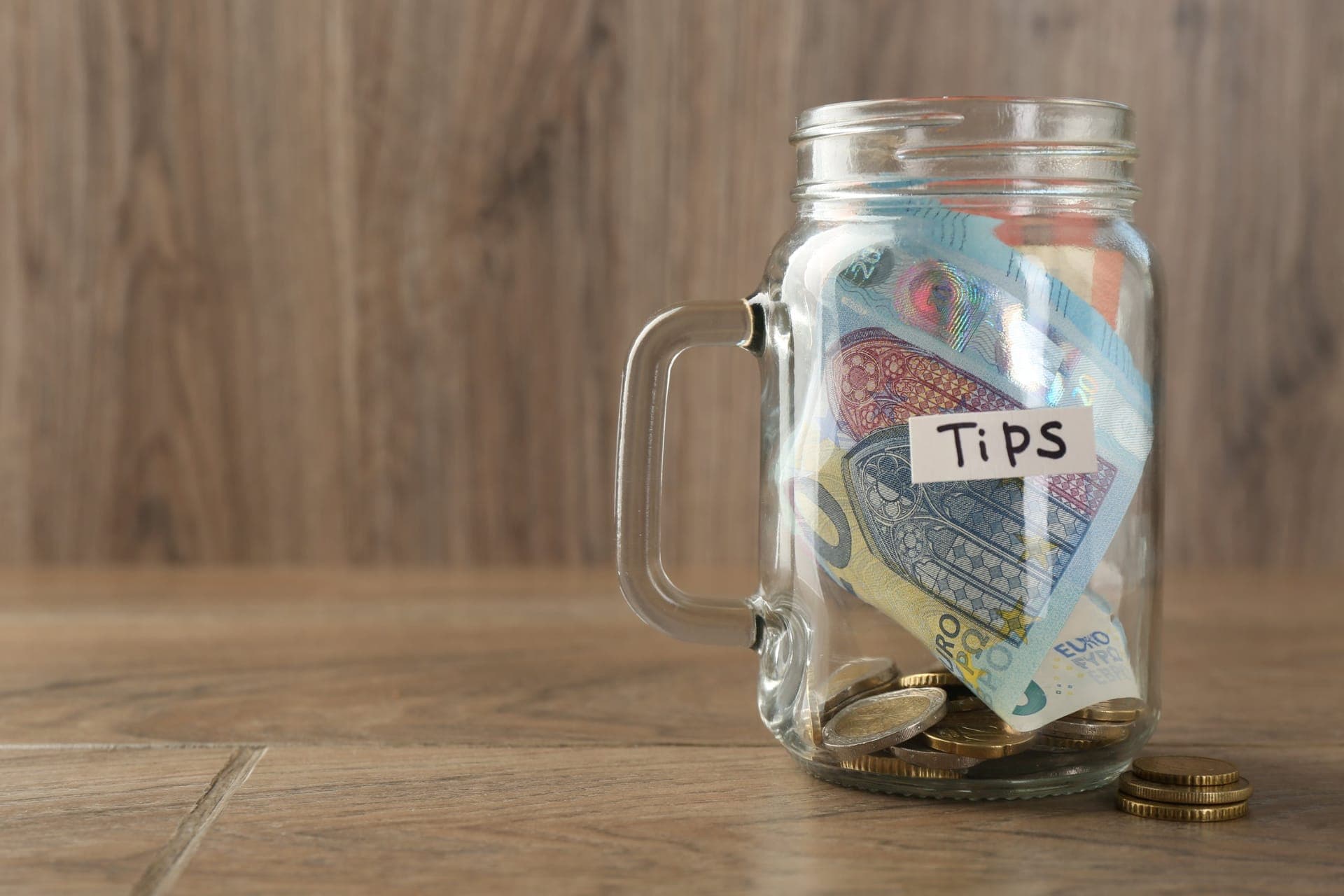Ein Trinkgeldglas gefüllt mit Euro-Scheinen und -Münzen