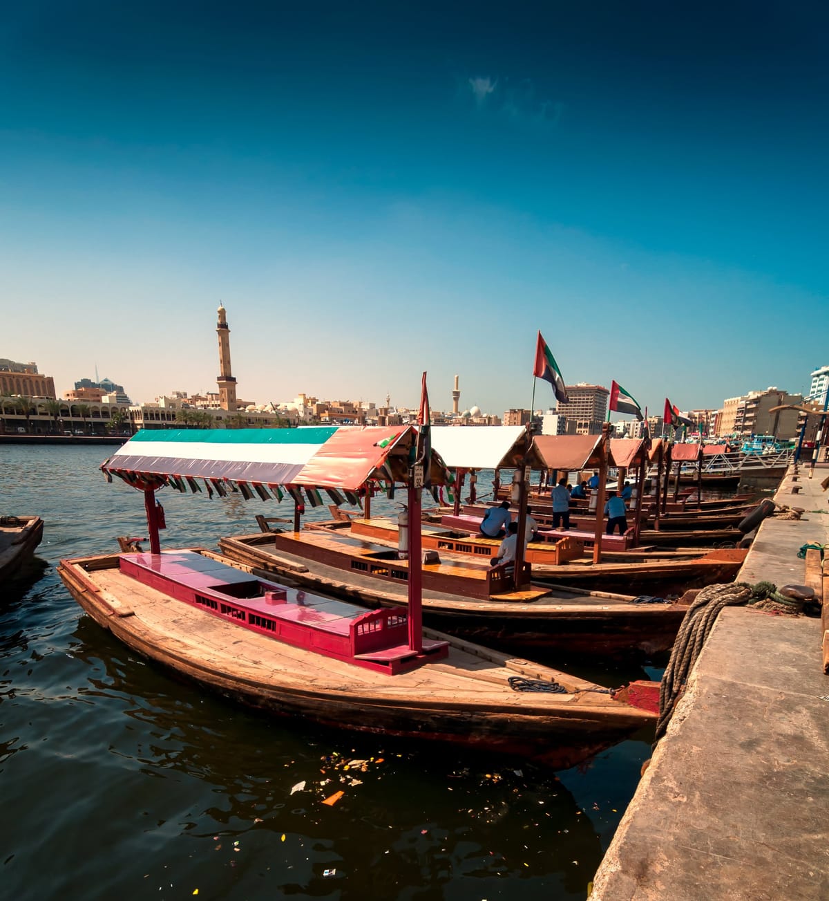 Traditionelle Abra-Holzboote auf dem Dubai Creek vor der Skyline von Deira