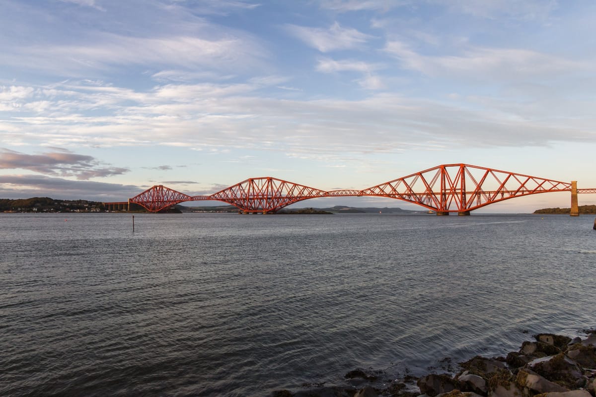 Die rote Forth Bridge (Eisenbahnbrücke) bei South Queensferry über den Firth of Forth, gern mit Booten im Vordergrund