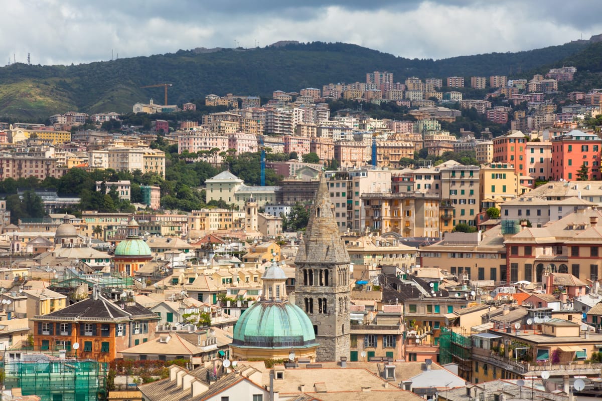 Blick über die farbenfrohen Fassaden der Genueser Altstadt vor den Hügeln Liguriens
