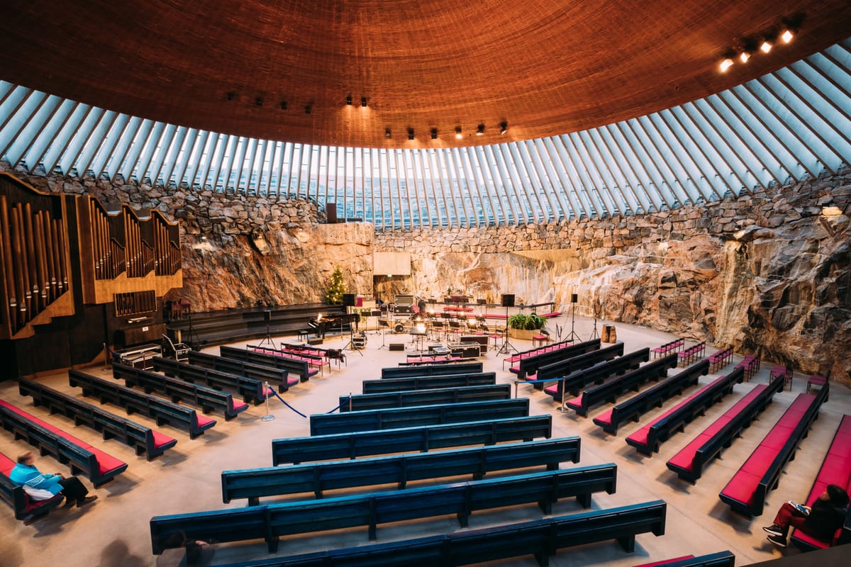 Der Innenraum der Felsenkirche Temppeliaukio mit Kupferkuppel über rohem Granit