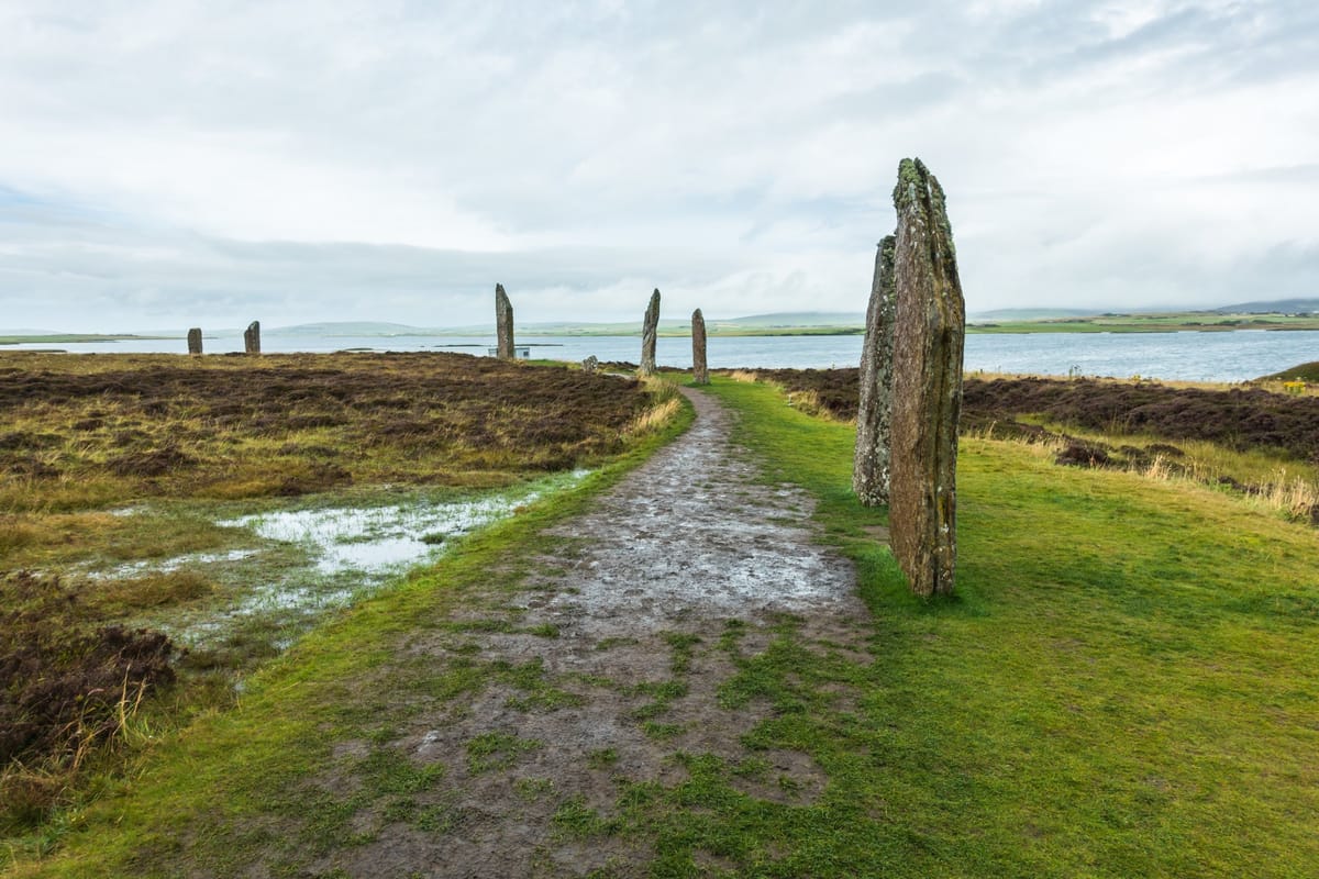 Der Steinkreis Ring of Brodgar auf Orkney mit mehreren aufrecht stehenden Steinen in grüner Landschaft