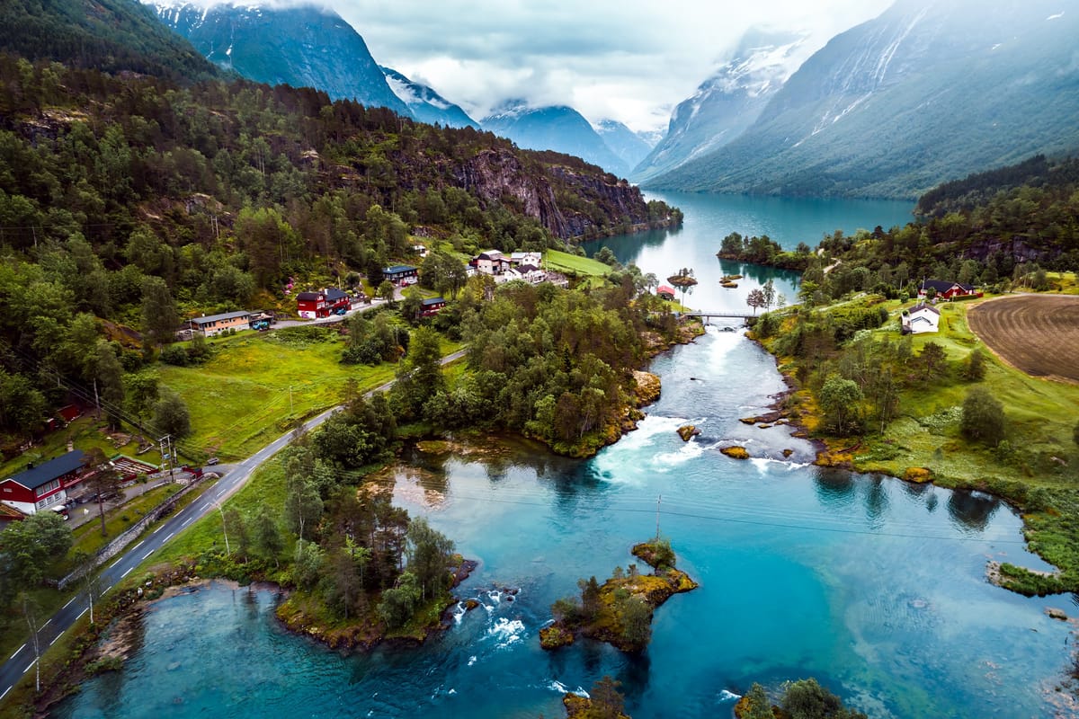 Türkisgrünes Wasser des Lovatnet mit Bergen und Gletscher im Hintergrund, klarer Sommertag
