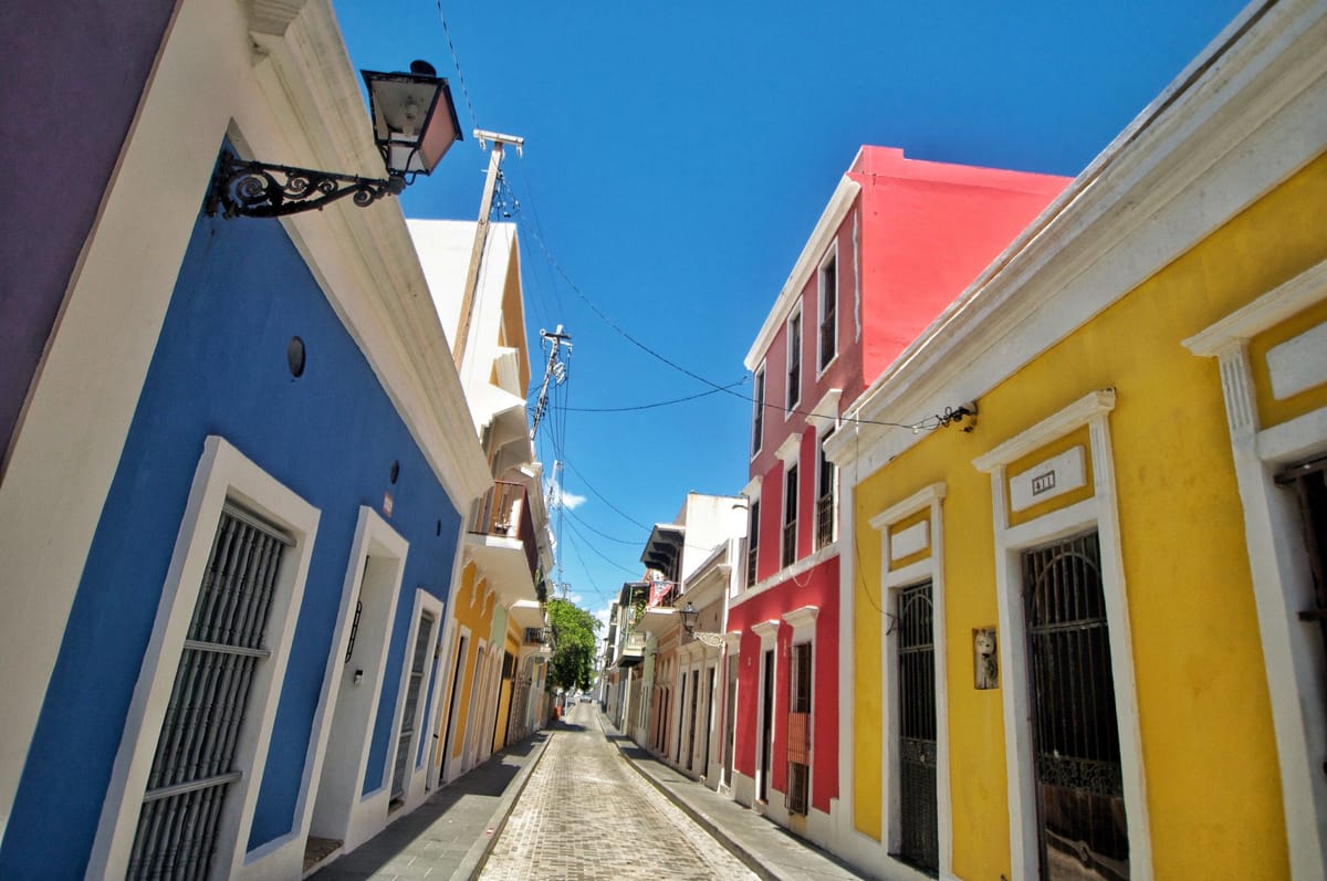 Bunte Kolonialhäuser in Blau, Rot und Gelb an einer engen Gasse in Old San Juan