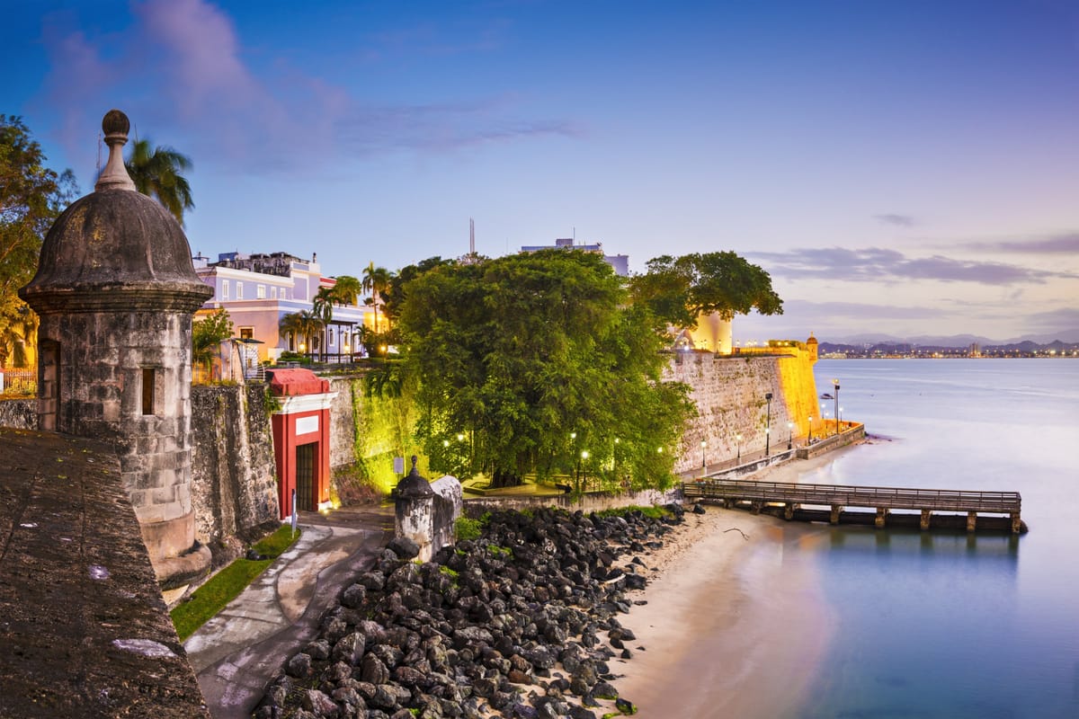 Uferpromenade Paseo de la Princesa mit Bäumen, historischen Laternen und der Stadtmauer von Old San Juan