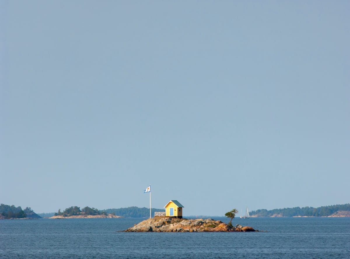 Felsige Schäreninseln mit roten Holzhäusern in der Ostsee vor Stockholm