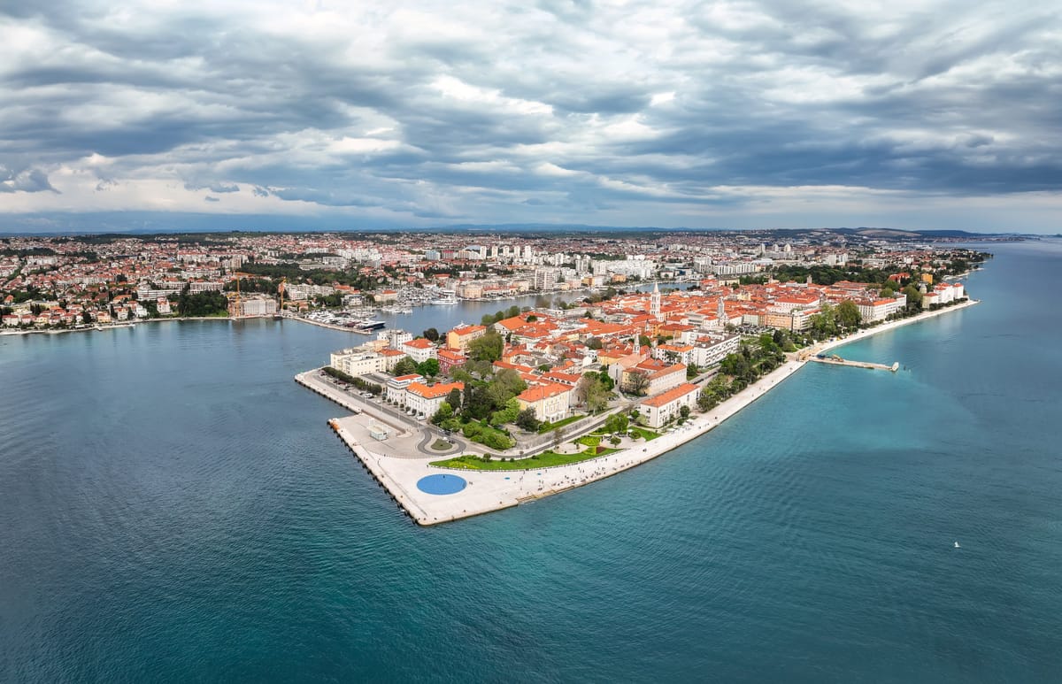 Luftbild der Halbinsel von Zadar mit Altstadt, Uferpromenade und der runden Glasfläche des Gruß an die Sonne an der Nordwestspitze