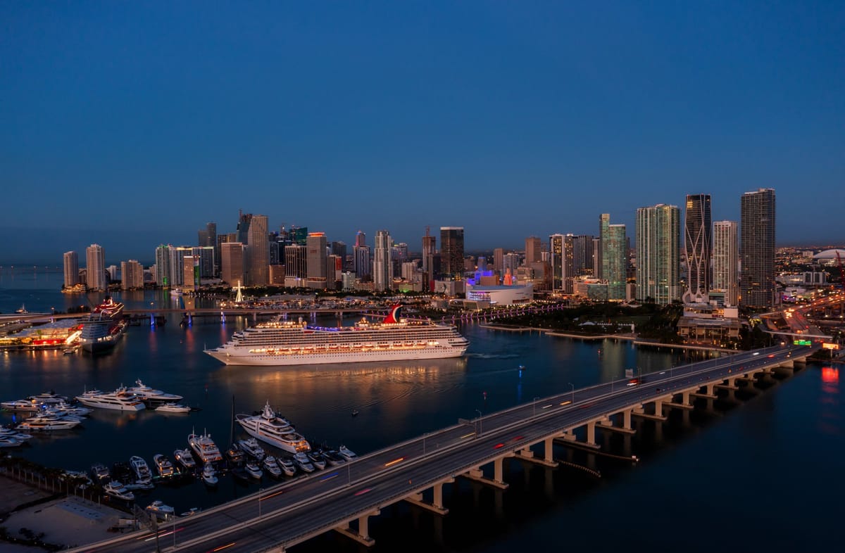 Großes Kreuzfahrtschiff im Größenvergleich neben einer Hafenskyline
