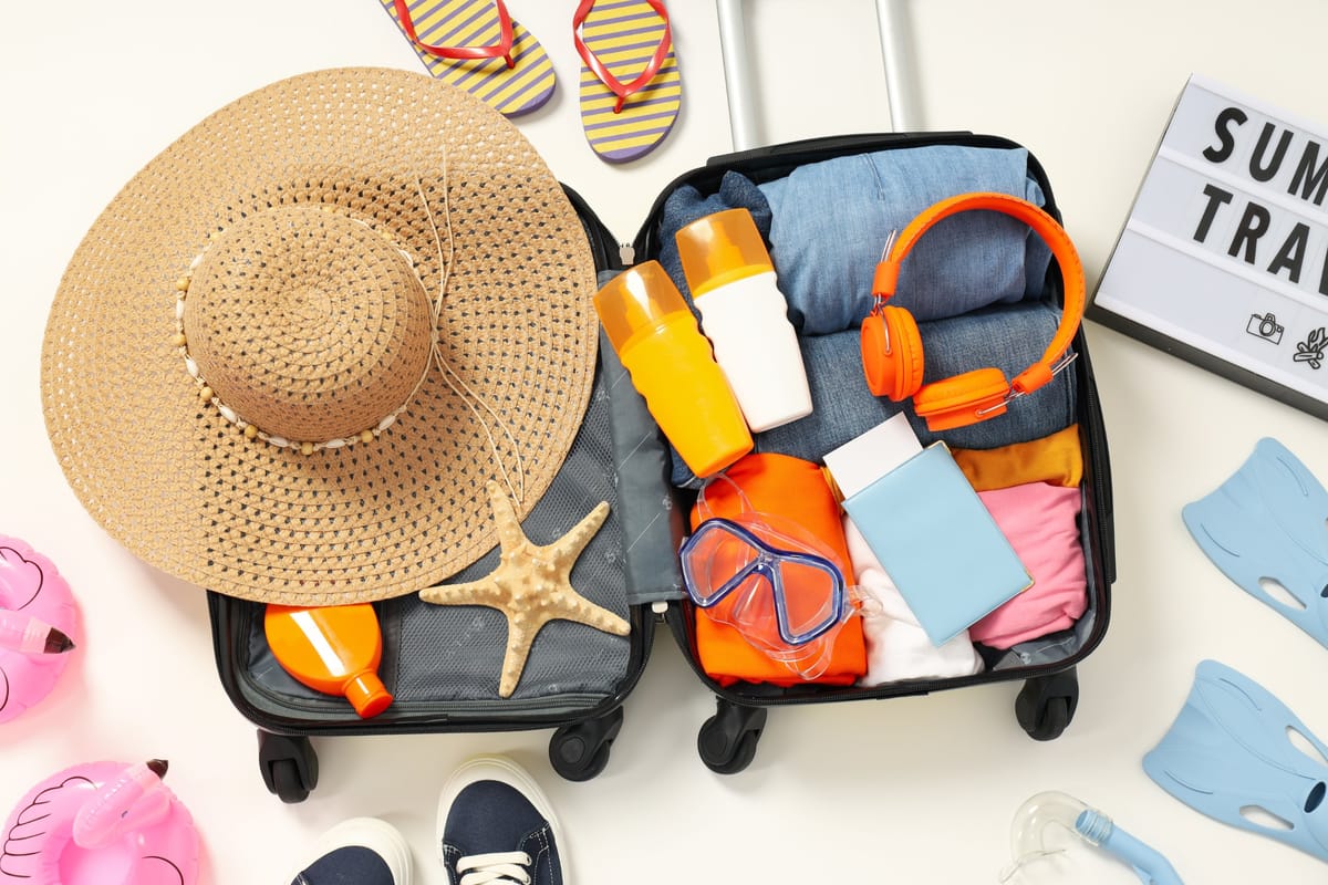 Gepackter Koffer mit Sommerkleidung, Schnorchelmaske und Sonnenhut
