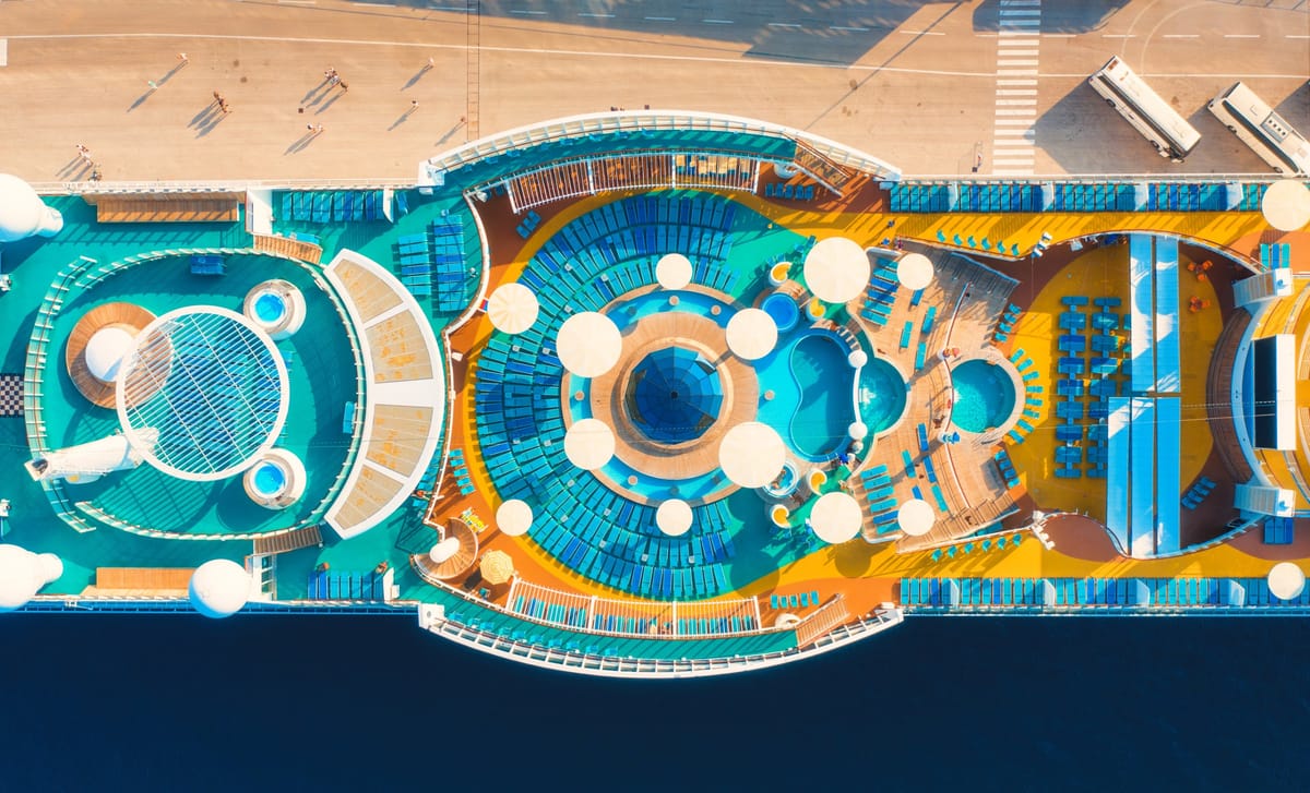 Pooldeck eines großen Kreuzfahrtschiffs mit Wasserrutschen und Attraktionen