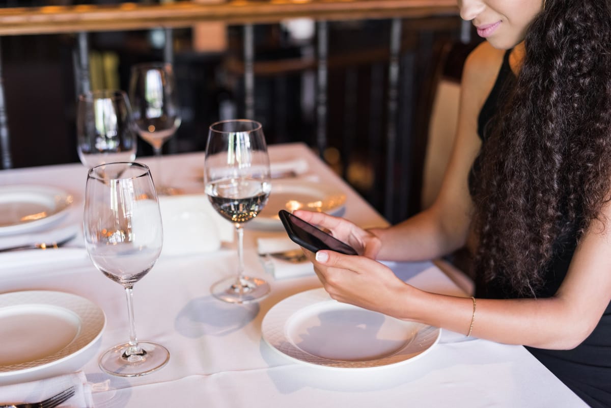 Person bucht eine Restaurant-Reservierung über eine App an Bord